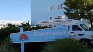 Un letrero de 'Courtyard by Marriott' con un vehículo estacionado cerca.