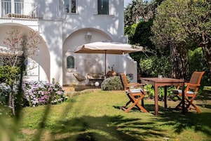 Un patio con mesa y sillas, una silla colgante y una lámpara.