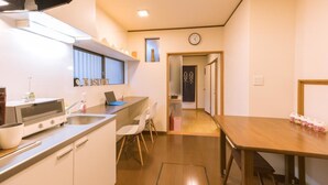 Una cocina compacta con tostadora, pileta y comedor con mesa y sillas.