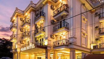 A multi-story hotel with a prominent sign reading "Praha Hotel".