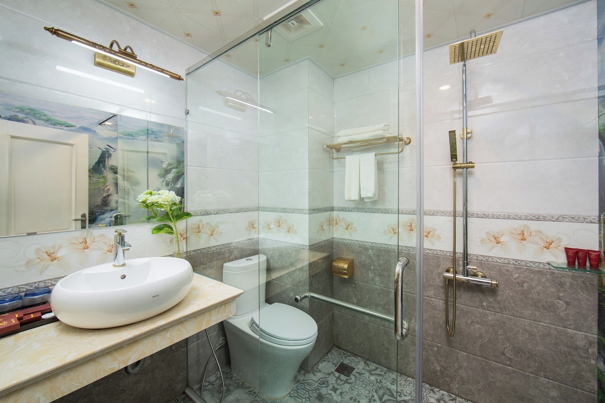 A modern bathroom with a glass-enclosed shower, a white sink, and a toilet.