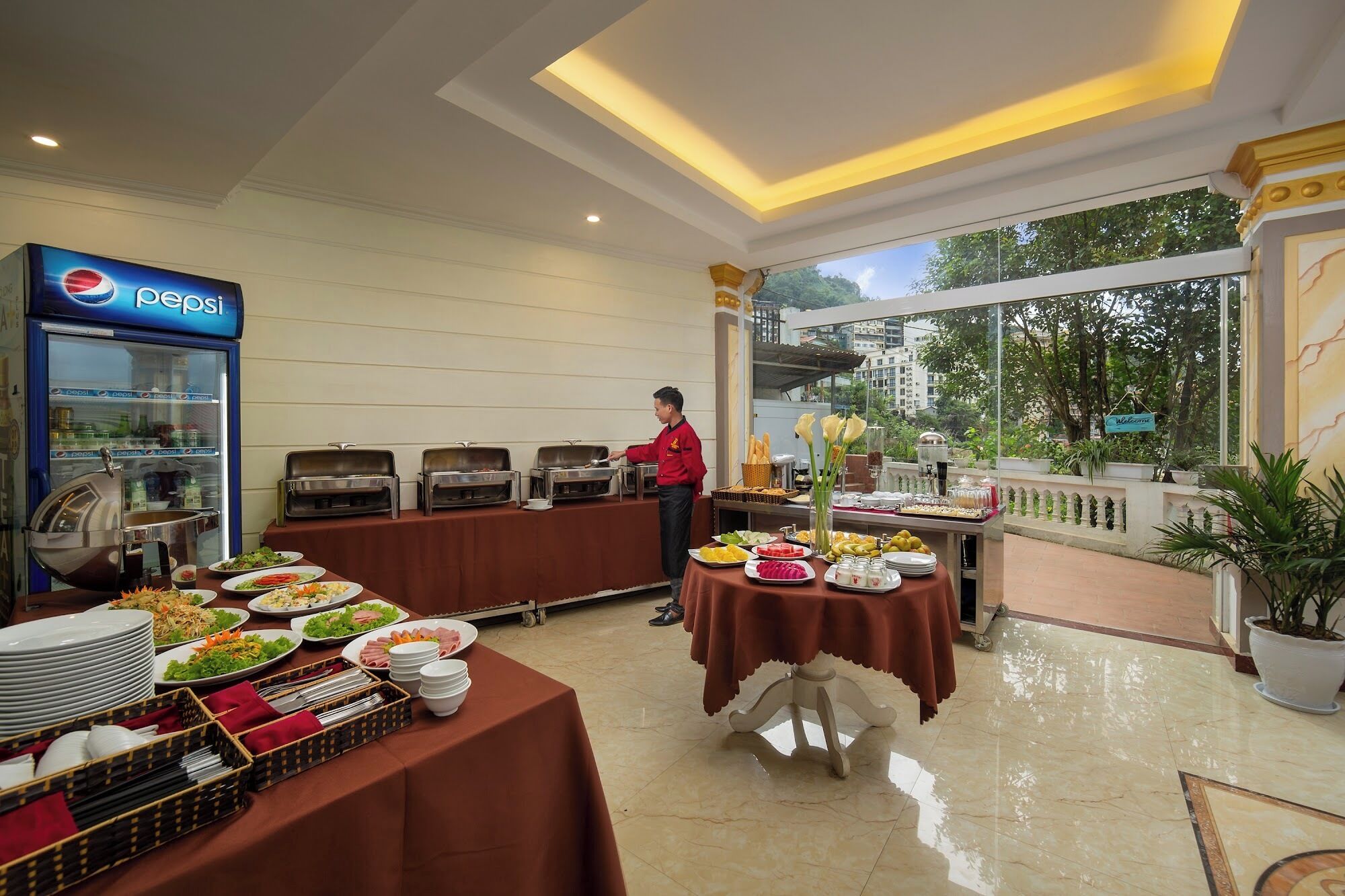A buffet setup with various food items and a Pepsi refrigerator.