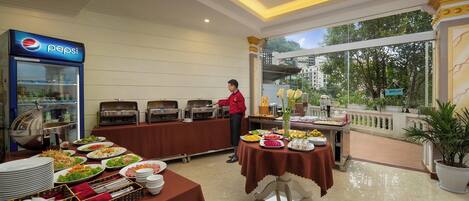 A buffet setup with various food items and a Pepsi refrigerator.