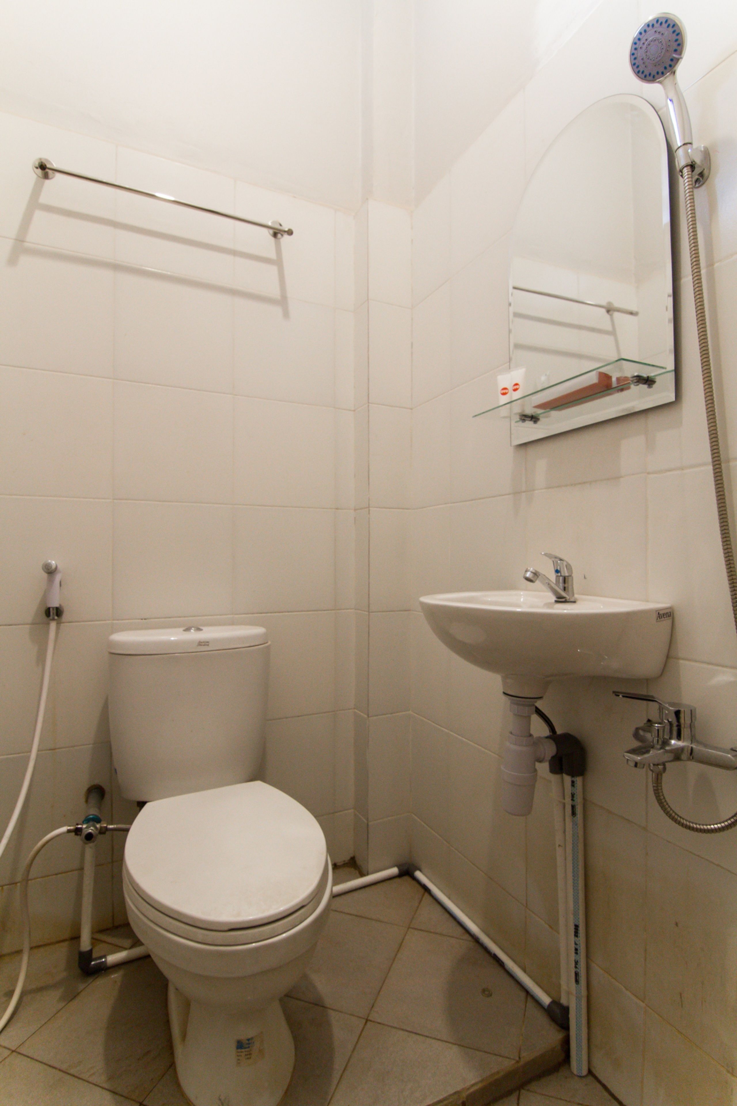 Une petite salle de bain avec des toilettes, un lavabo et une douche.