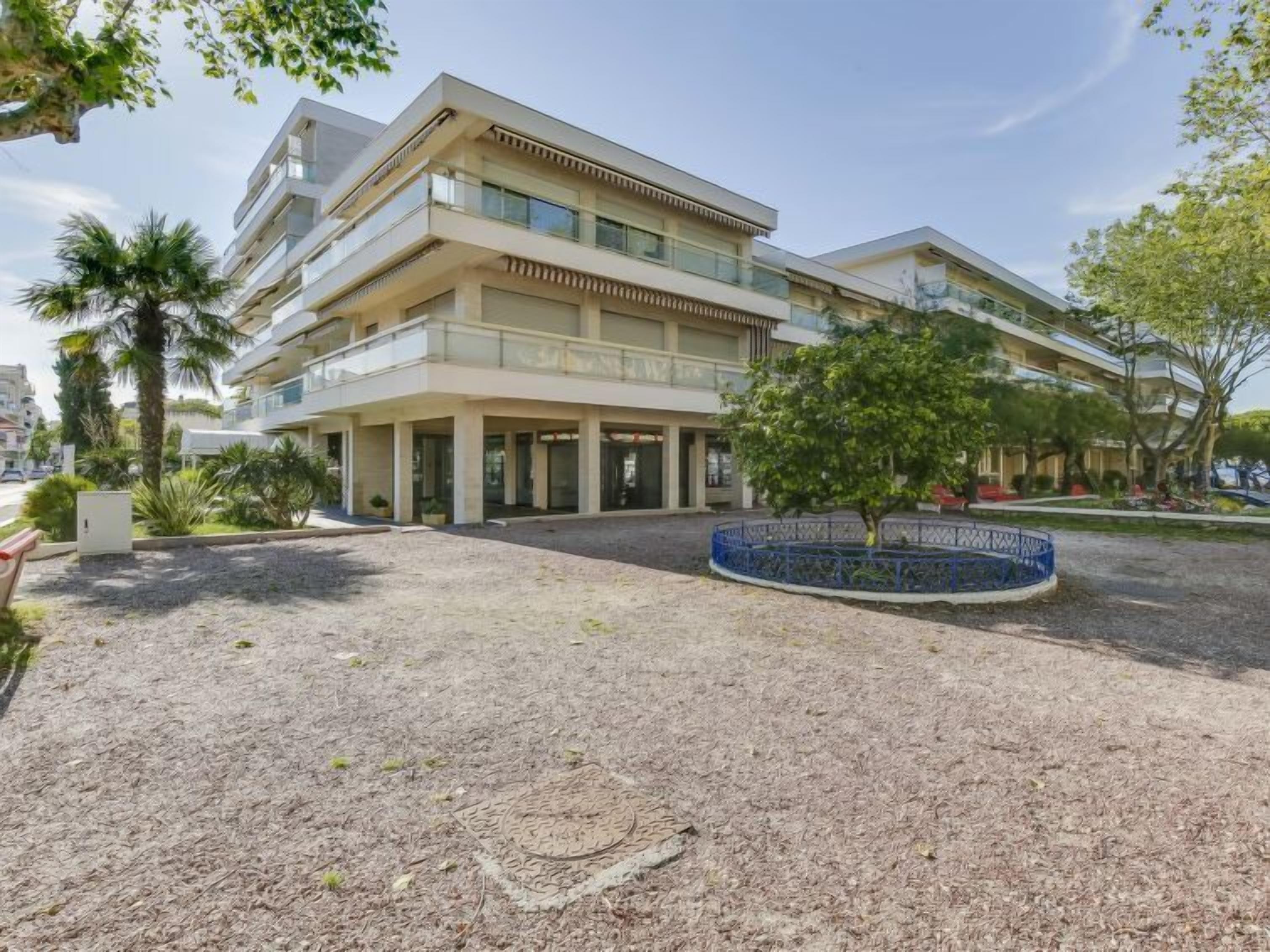 A multi-story hotel with a central courtyard, outdoor seating, and a small fountain.