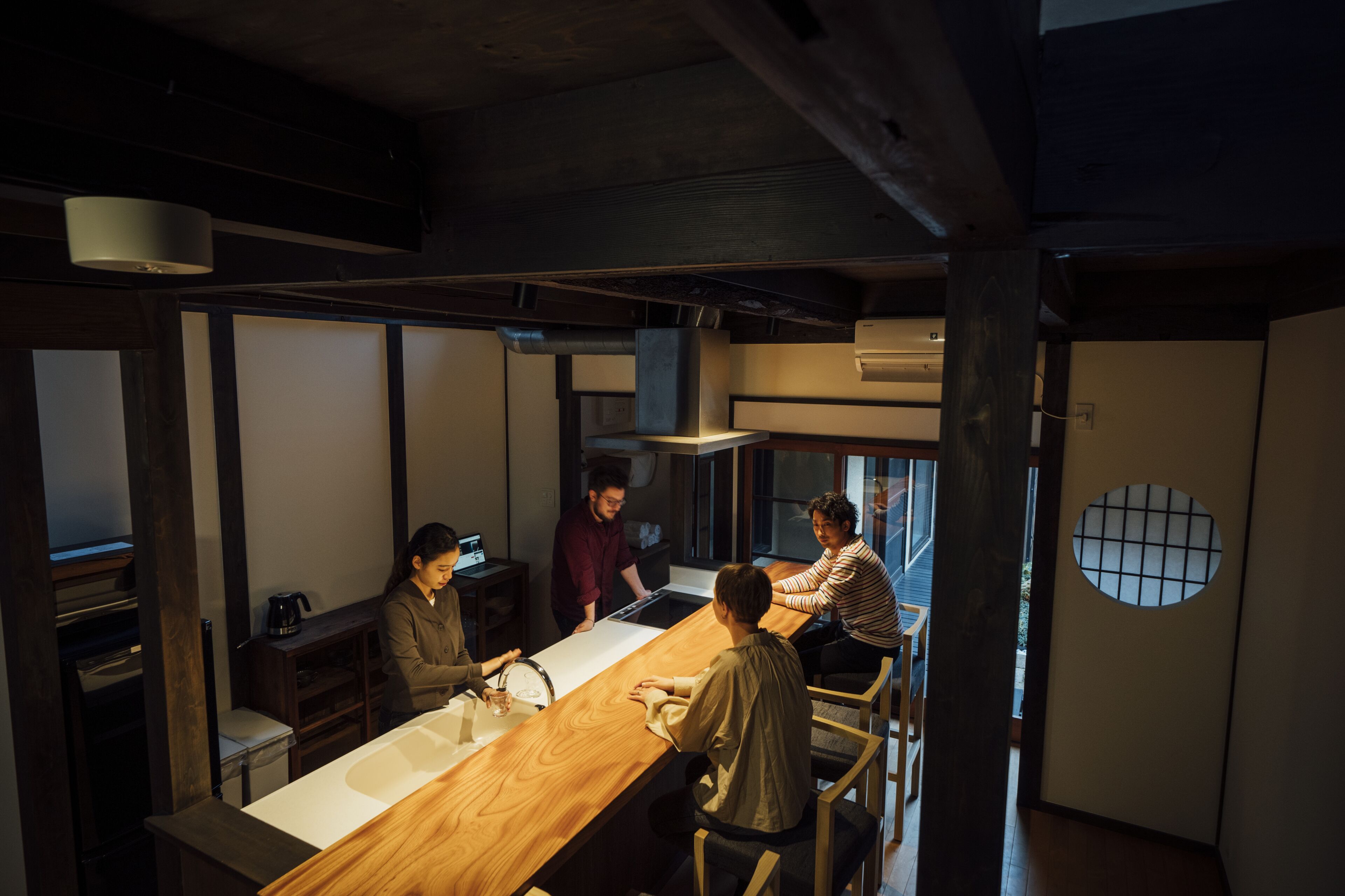 A modern kitchen with a wooden countertop, built-in appliances, and a large window.