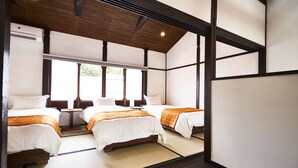Een hotelkamer met twee bedden, een houten plafond en een groot raam.