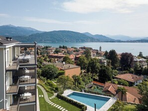 A residential area with a swimming pool, a balcony, and a view of a lake and mountains. - The View-Earth: design apt. with lake view (Baveno)
