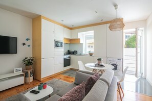 A modern apartment with a living room, kitchen, and dining area.