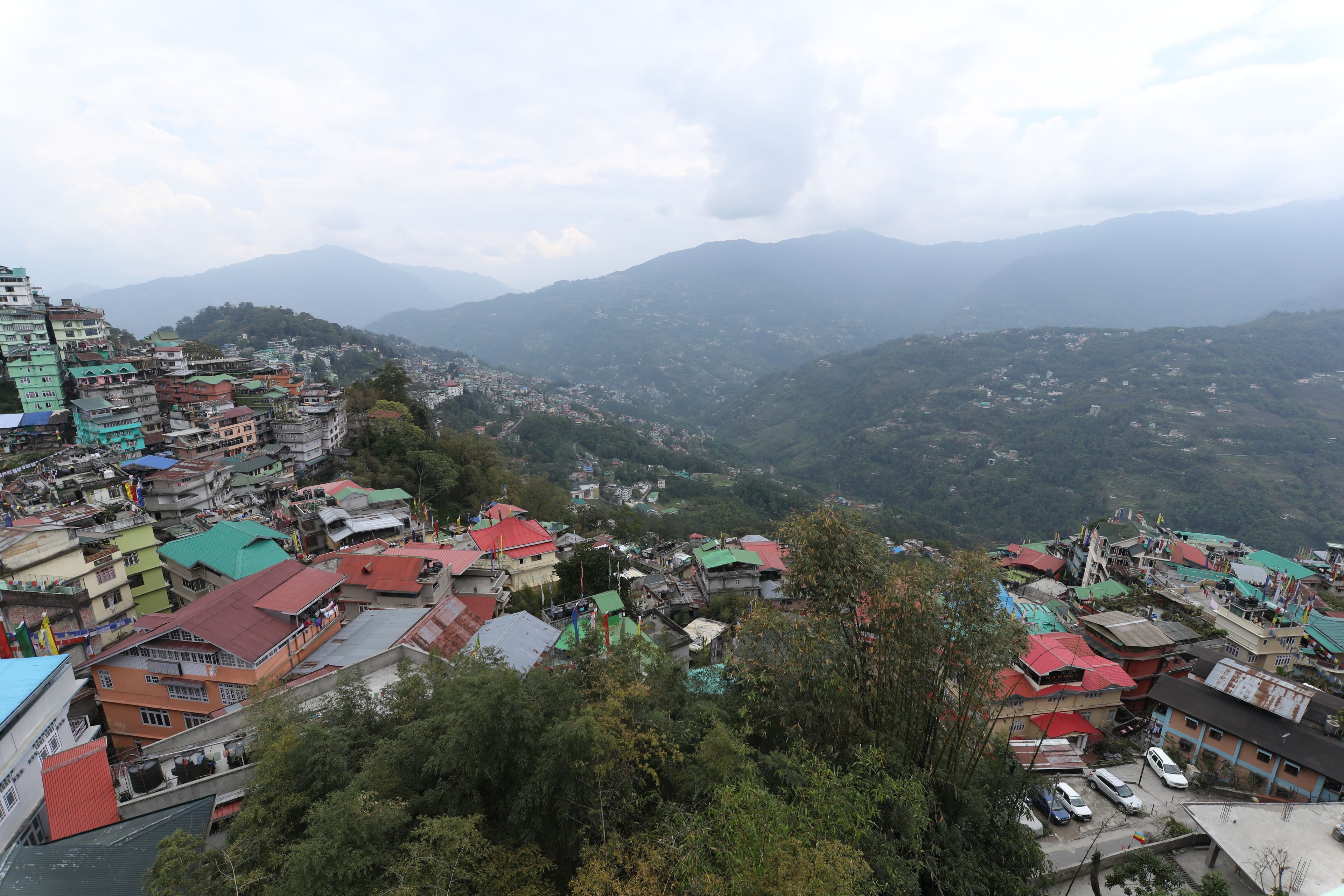 A mountainous town with colorful buildings and a view of distant hills.