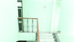 A staircase with a wooden handrail leading to a landing. - Hotel Tenancy (Gangtok)