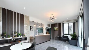 Una sala moderna con una isla central, zona de estar y una cocina al fondo.