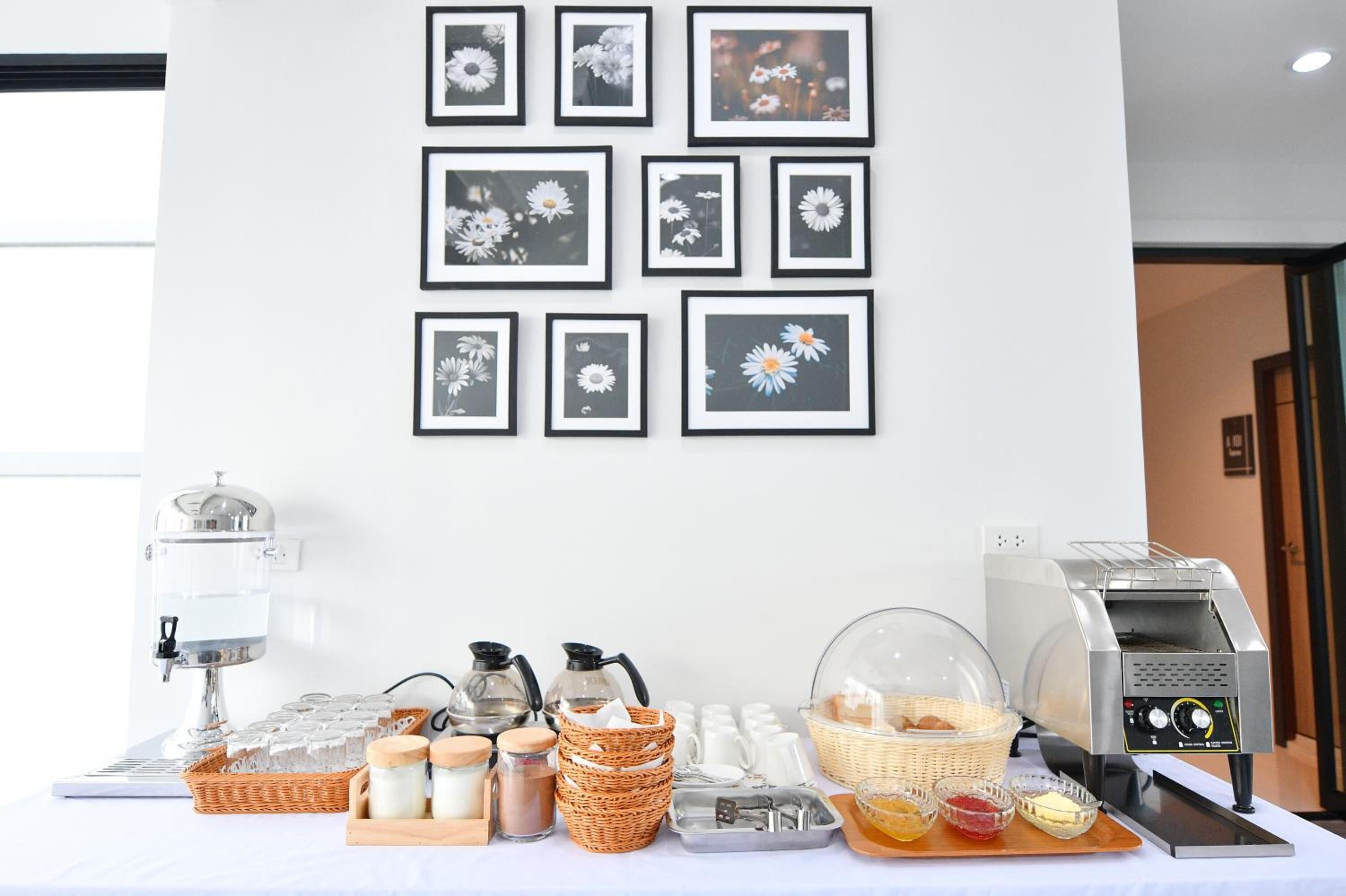 A breakfast buffet setup with a coffee machine, tea station, and various food items.