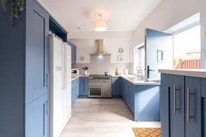 Bright kitchen with back door opening to the raised decked dining area, pet-friendly beachside cottage sleeping six in Rhosneigr, Anglesey - Lan Y Mor: The perfect escape amongst the dunes (Rhosneigr)