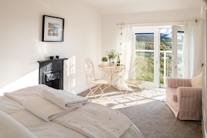 Relax in a serene bedroom with a large bed, dresser, and comfortable seating area.