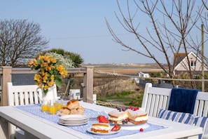 Raised decked dining area to the rear, perfect for morning coffee at pet-friendly beachside cottage in Rhosneigr, Anglesey