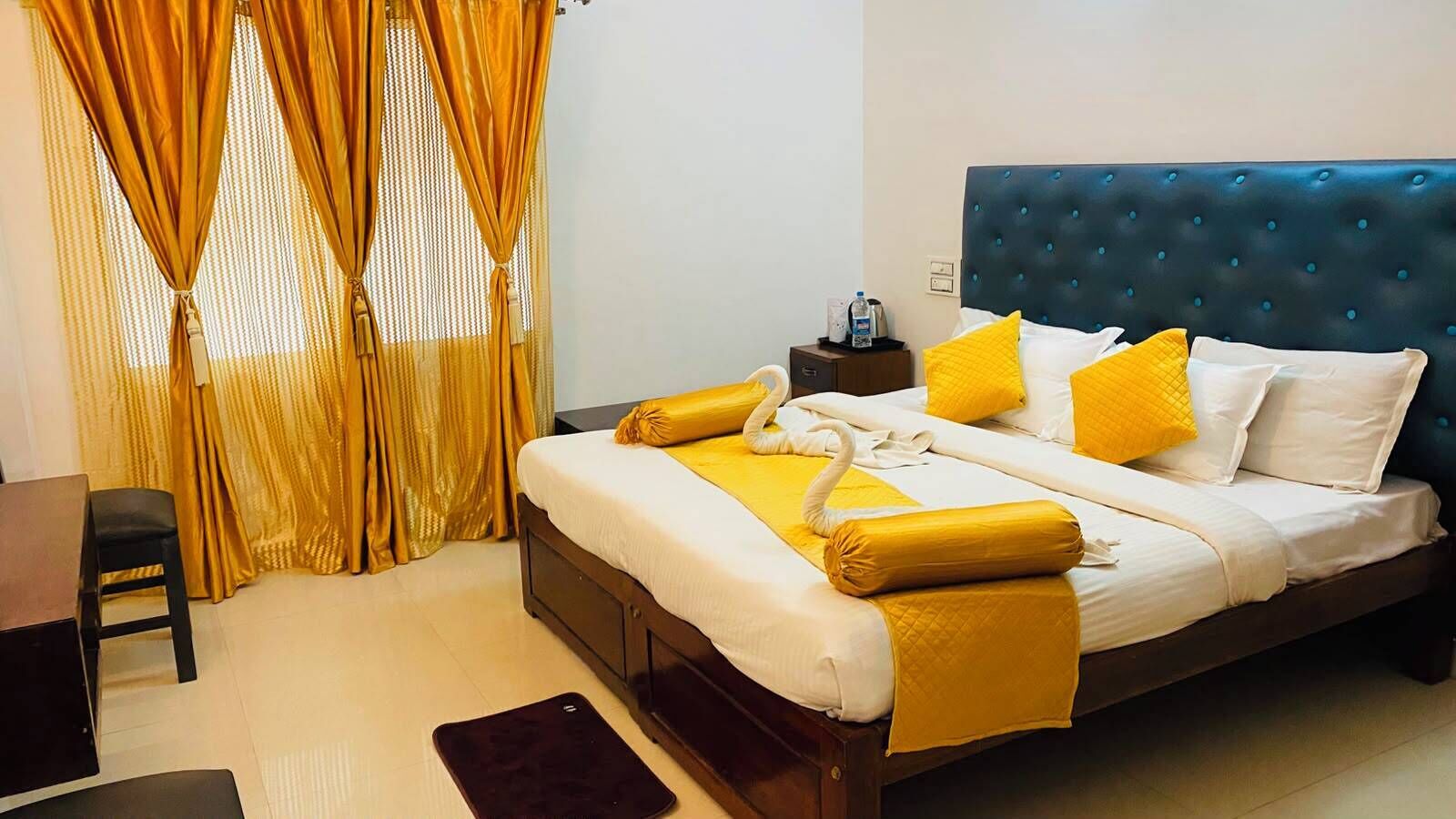 A hotel room with a bed, a nightstand, a chair, and a desk.