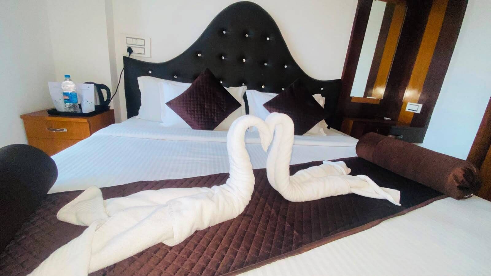 Una cama con cabecera, almohadas y una manta.