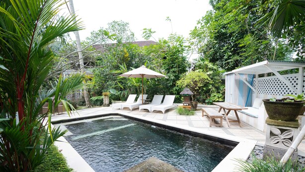 A swimming pool with lounge chairs and a gazebo in a lush garden setting. - Sayan Ridge Villa (Ubud)