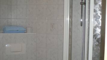 Ein Badezimmer mit Toilette, Dusche und Handtuchhalter.