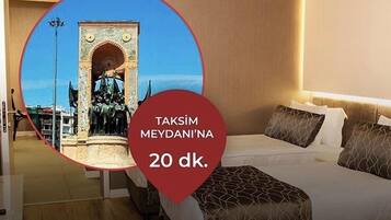 A hotel room with a bed, pillows, and a view of a historical monument.