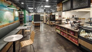 Un café avec un comptoir, un espace pour s’asseoir et un tableau affichant le menu.