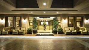 Un hall d’hôtel comprenant un comptoir d’accueil, un espace salon et des plantes en pot.