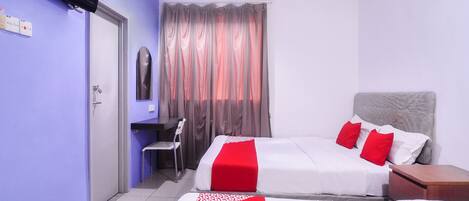 A hotel room with a bed, a desk, a chair, a TV, and a window with curtains.