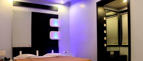 A modern bedroom with a bed, bedside tables, and a mirror.