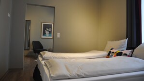 A hotel room with two beds, a chair, a framed picture on the wall, and a window with curtains. - Gästehaus Sonne (Triefenstein)