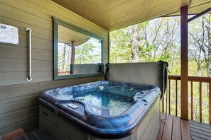 Un bain à remous sur une terrasse en bois, dotée d’une rambarde, d’une main courante et d’un miroir fixé au mur.