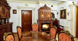 A formal dining room with a wooden table, chairs, a fireplace, and ornate furniture. - Straszny Dwor (Koscielisko)
