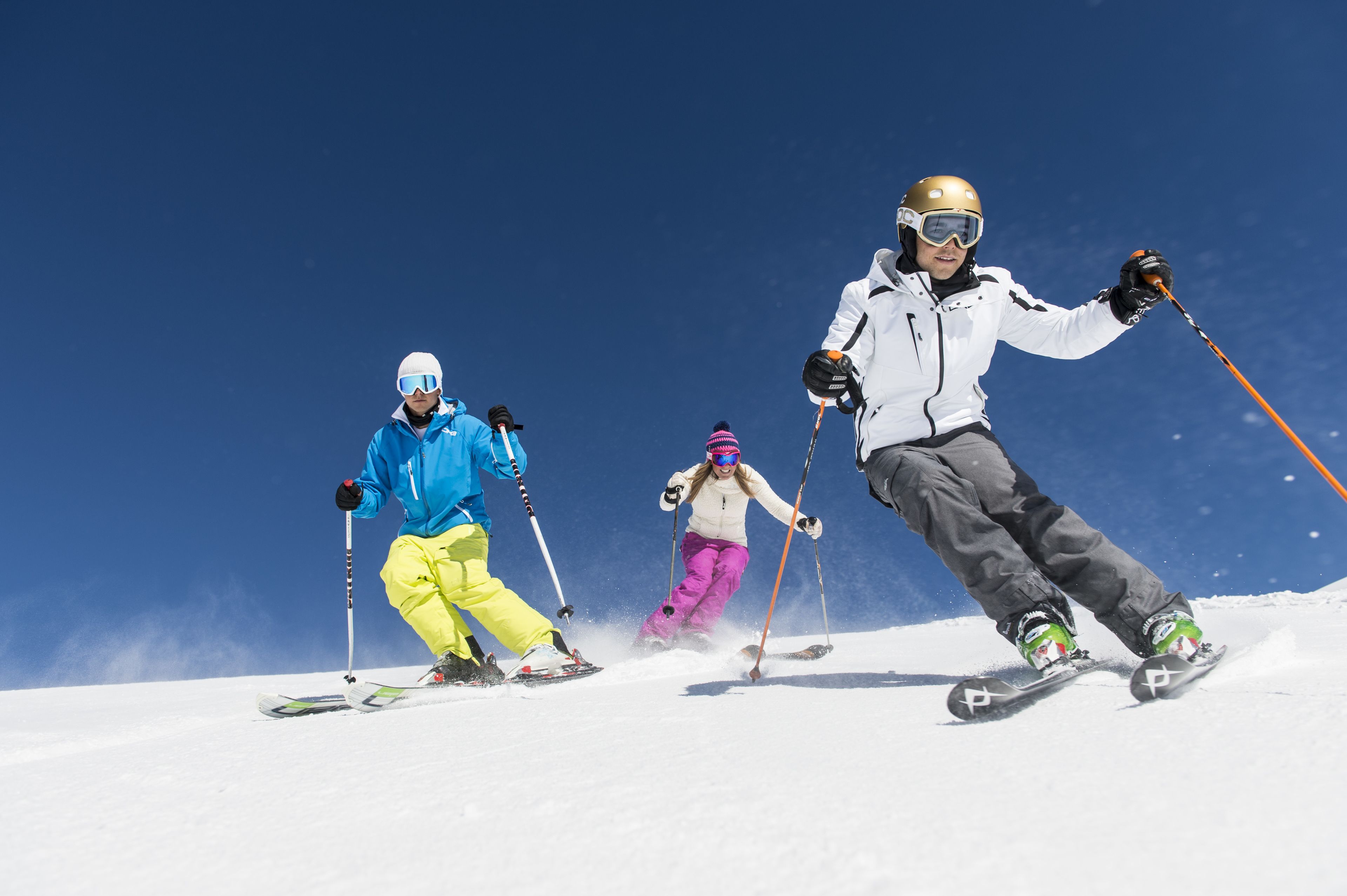 Three skiers on a snowy slope.