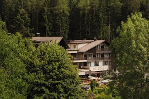 Un edificio de varios pisos llamado 'WALDRAST' rodeado de un bosque denso.