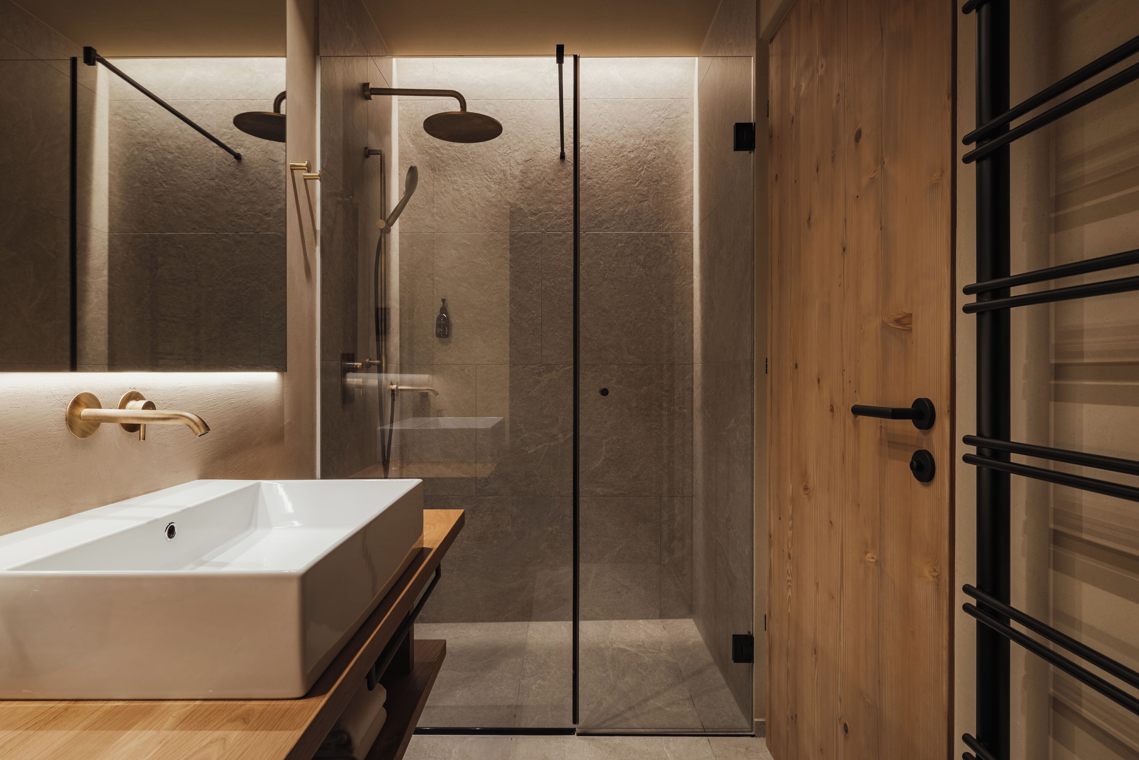 Ein modernes Badezimmer mit einem großen, rechteckigen Waschbecken, einer gläsernen Dusche und Holzvertäfelung.