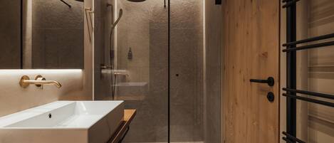 Ein modernes Badezimmer mit einem großen, rechteckigen Waschbecken, einer gläsernen Dusche und Holzvertäfelung.