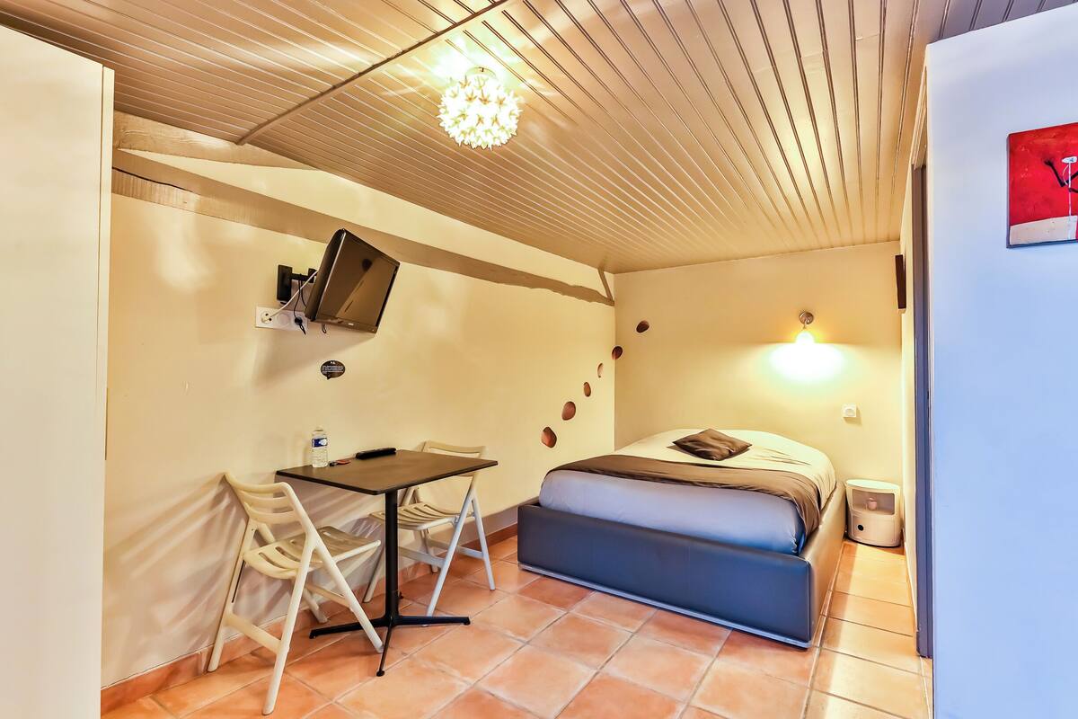 Une petite pièce comprenant un lit, un bureau et une chaise.
