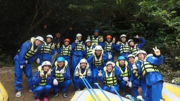 A group of people in blue and yellow safety gear posing with inflatable rafts.