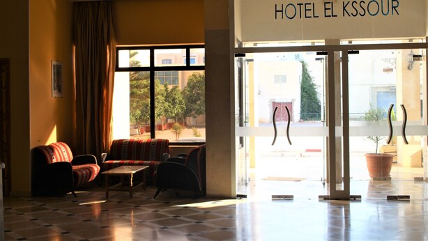 A hotel lobby with a check-in desk, seating area with sofas, and large windows. - Hotel El Kssour (Medenine)