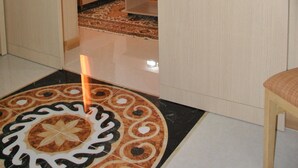 A hotel room with a bed, a nightstand, and a patterned rug. - Hotel El Kssour (Medenine)