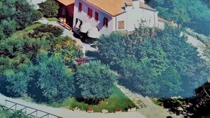 A two-story house with a red-tiled roof, surrounded by lush greenery and a small garden. - Agriturismo Ai Gradoni (Teolo)