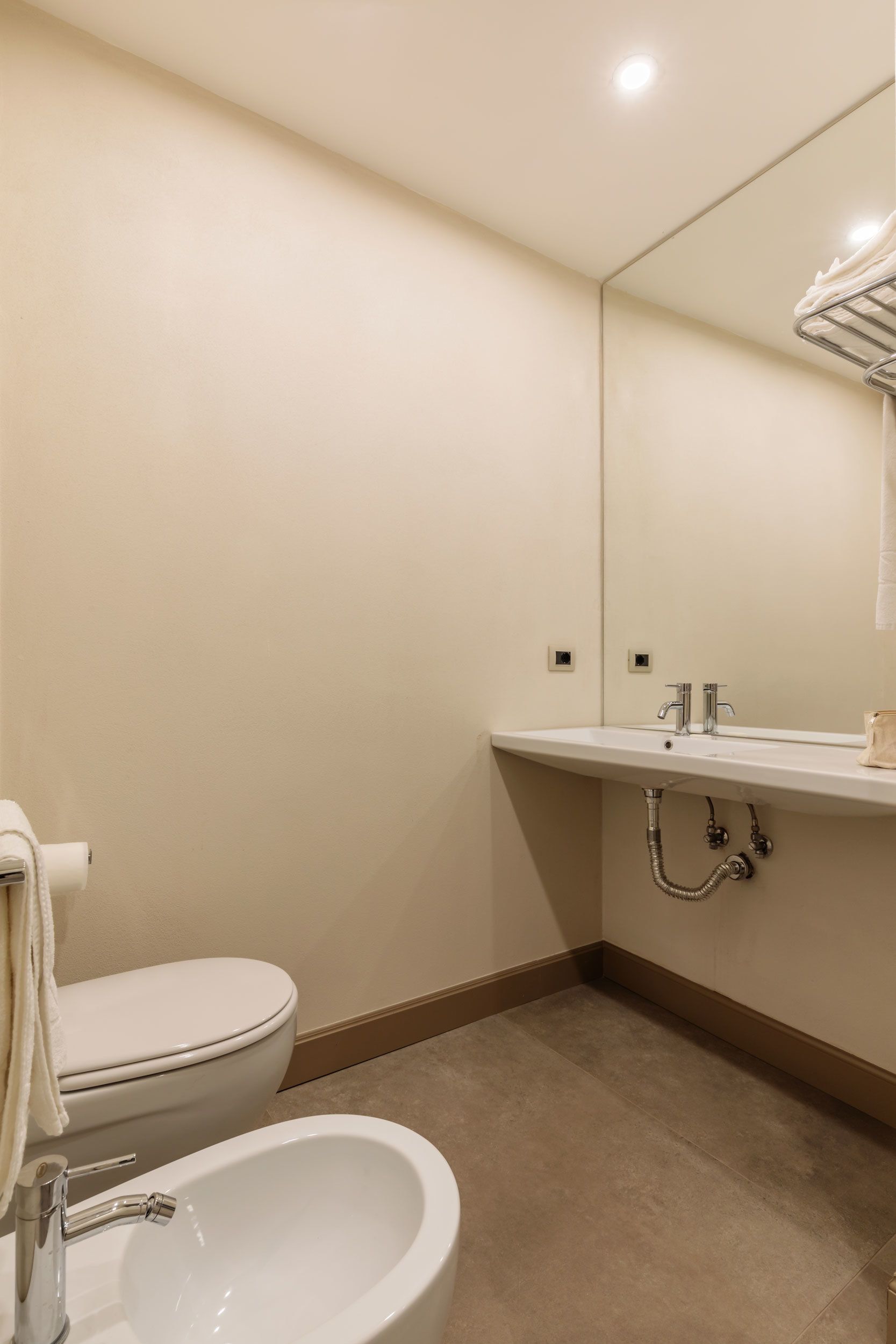 Un bagno con il water, un lavandino e uno specchio.