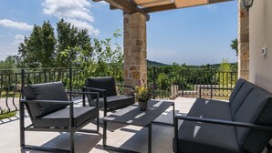 An outdoor patio with a pergola, stone pillars, and a view of the countryside. - Villa Irma in Golas, Croatia (Golas)