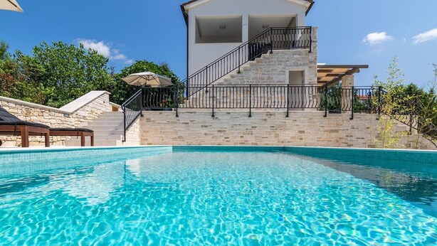 A clear blue pool with stone steps leading to a white building with a balcony. - Villa Irma in Golas, Croatia (Golas)