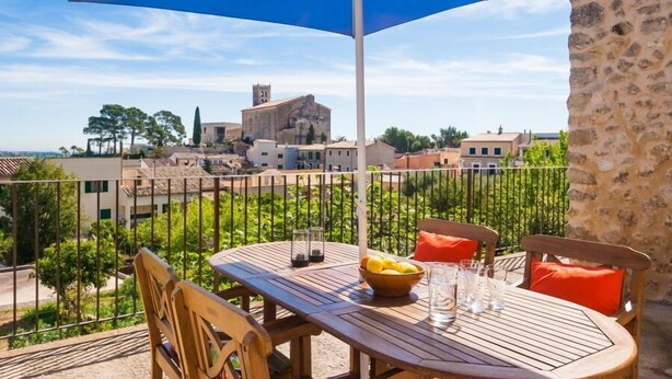 A balcony with a table, chairs, and a blue umbrella. - MARGARITA SAMPOL PALOU Can Selva, village house with fantastic views as far as Pto. Alcudia (SELVA)