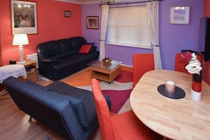Apartamento, 3 quartos | Sala de estar | TV de tela plana