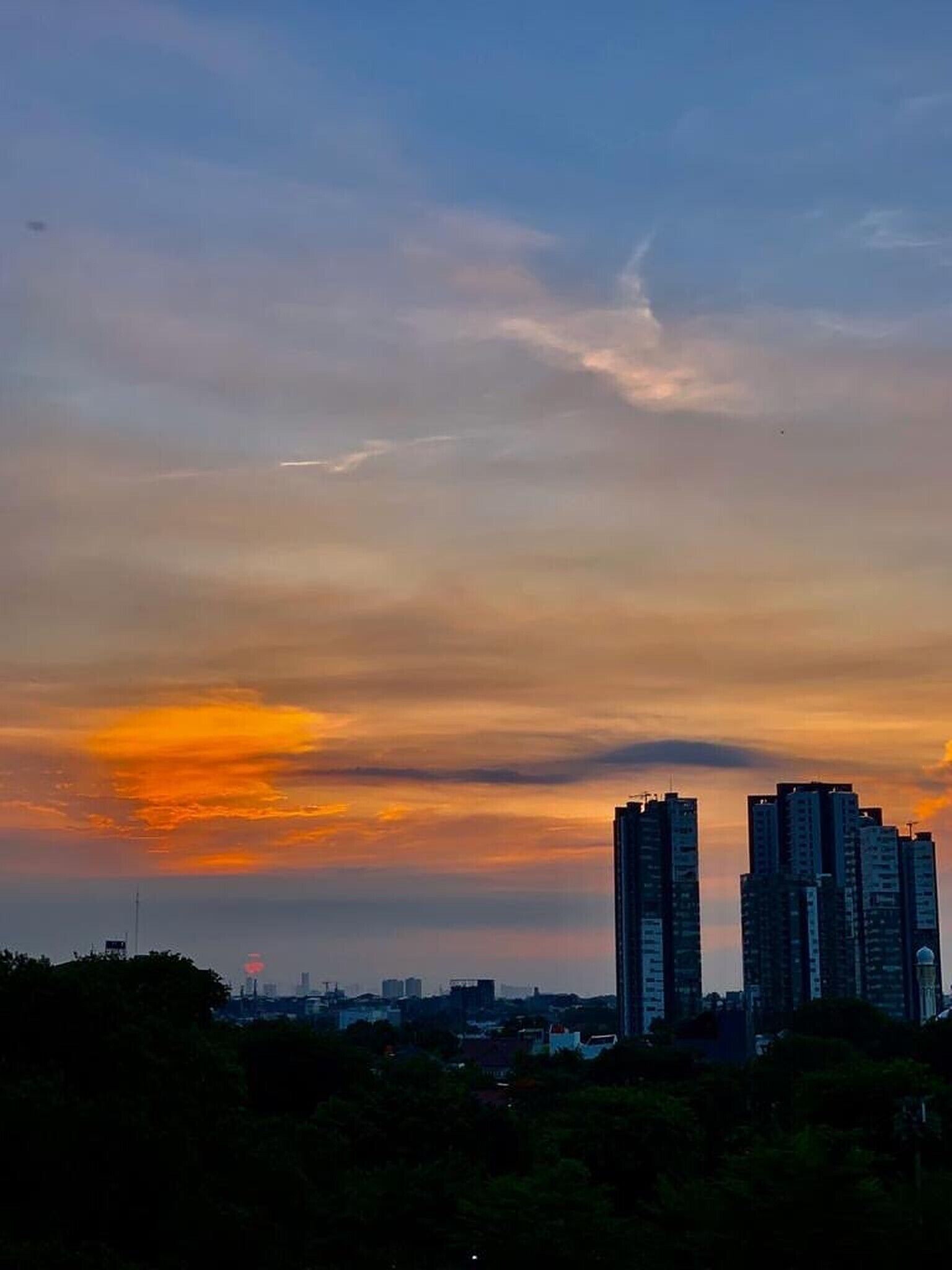 A cityscape with high-rise buildings during sunset.
