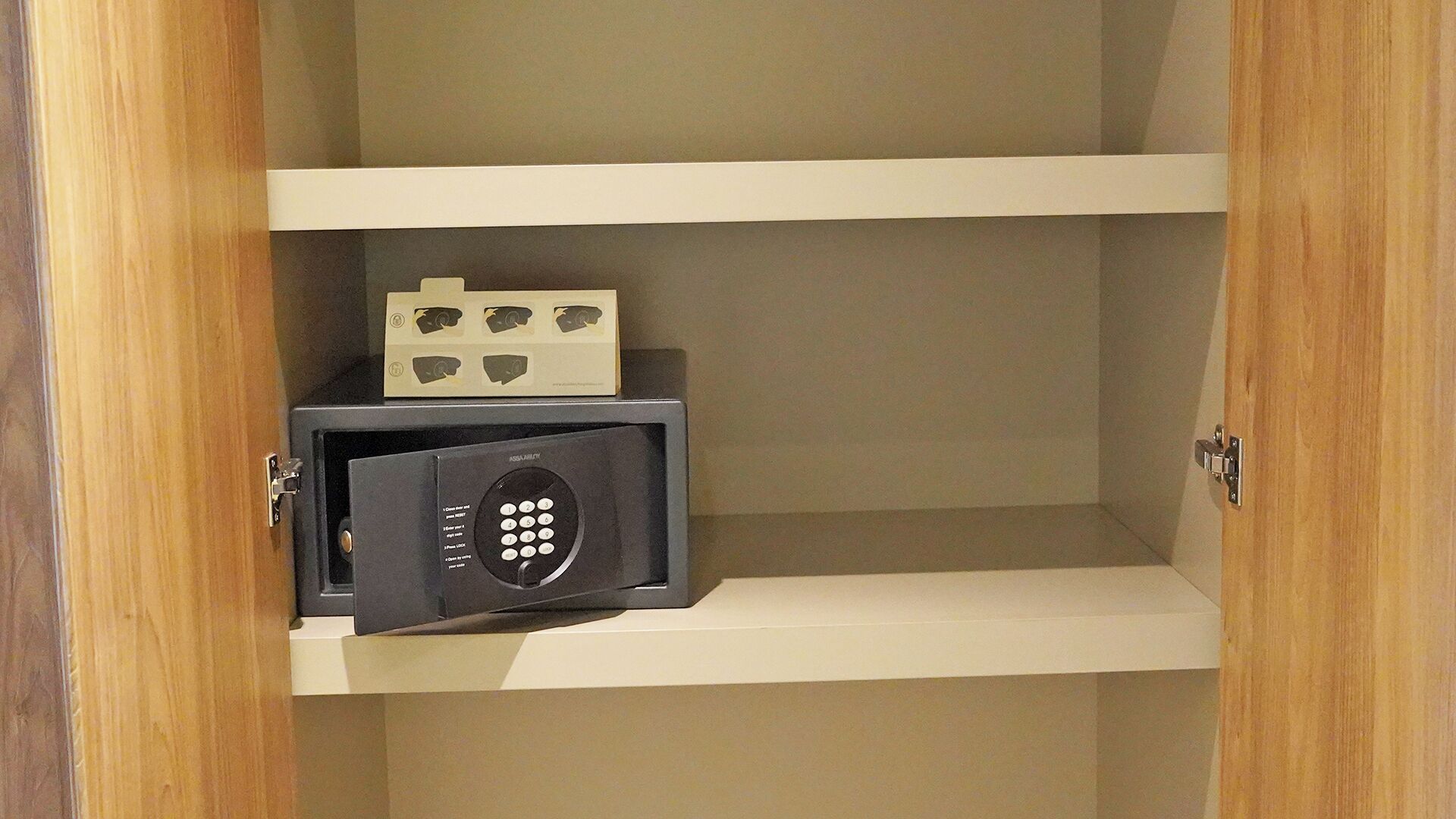 A secure storage unit with a combination lock and a small safe on a shelf.