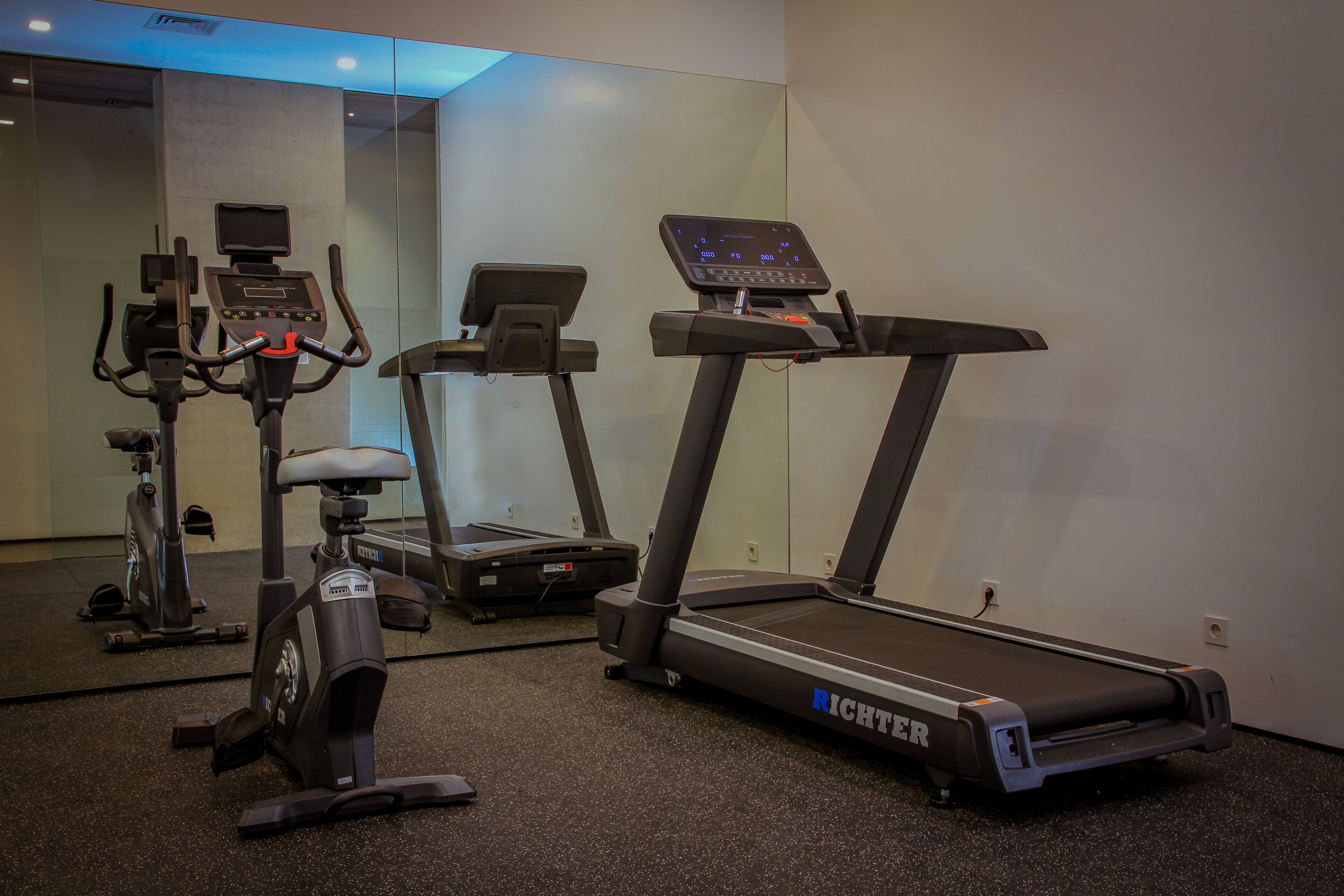 A gym with treadmills, an elliptical, and a stationary bike.
