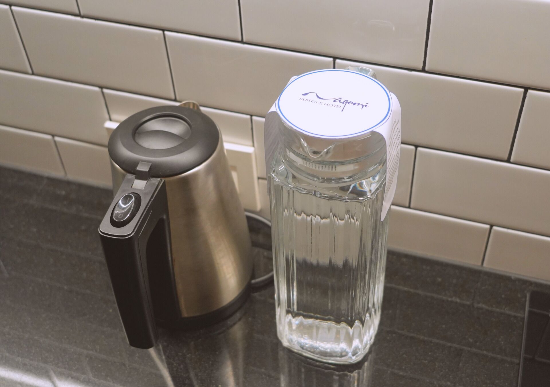 Una encimera de cocina con una cafetera y un tarro de vidrio.